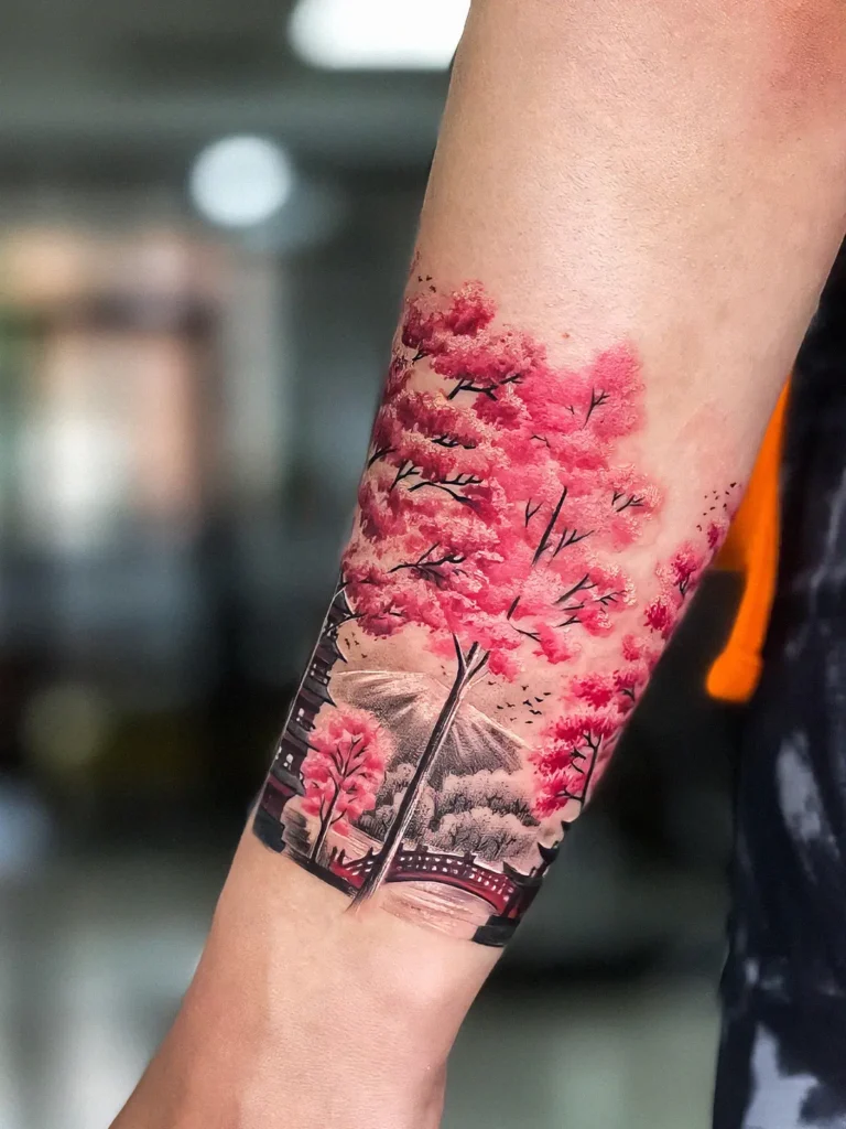 Tatovering med motiv japansk kirsebærtræ med bjerge i baggrunden